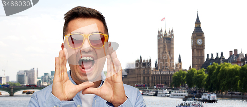 Image of face of angry shouting man in shirt and sunglasses