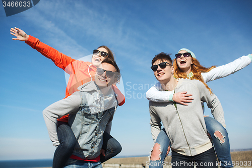 Image of happy friends in shades having fun outdoors