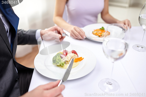 Image of close up of couple eating appetizers at restaurant