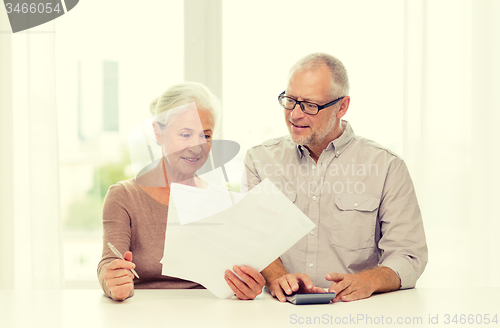 Image of senior couple with papers and calculator at home