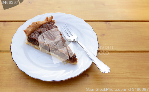 Image of Slice of pecan pie on a china plate with a fork