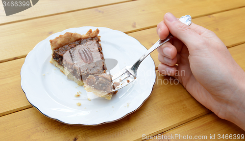 Image of Woman holding a bite of pecan pie on her fork