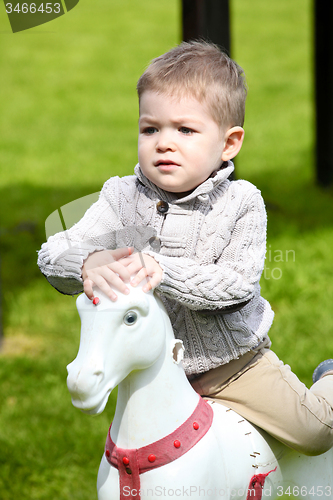Image of 2 years old Baby boy playing with horse