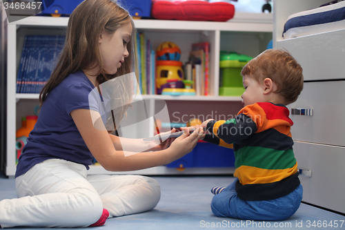 Image of girl and her little brother arguing with a digital tablet comput