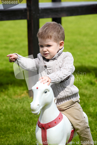 Image of 2 years old Baby boy playing with horse