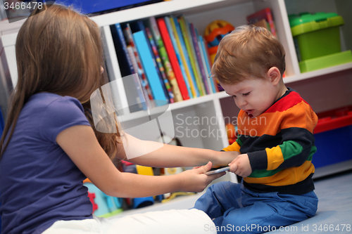 Image of girl and her little brother crying and arguing with a digital ta
