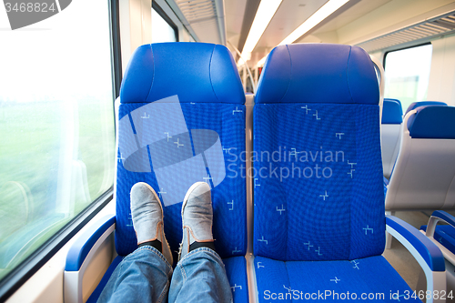 Image of Traveling alone in a trein, feet on the seats