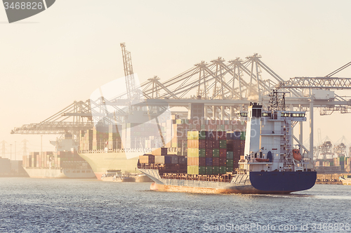 Image of Container ships arriving and being unloaded at a transhipment ha