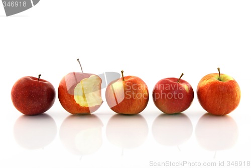 Image of One half-bitten apple among the whole ones