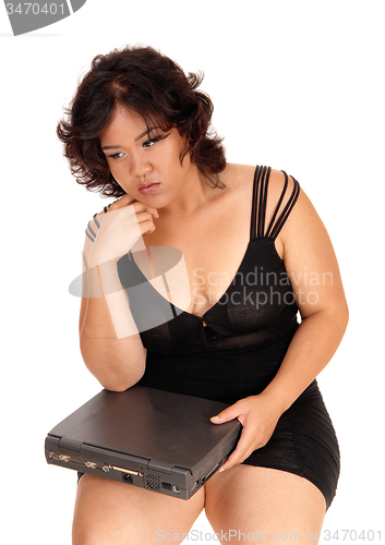 Image of Sad woman holding broken laptop.