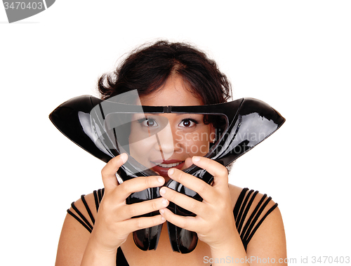 Image of Beautiful woman holding high heels on face.