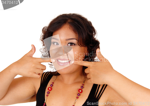 Image of Smiling woman pointing at he teeth.