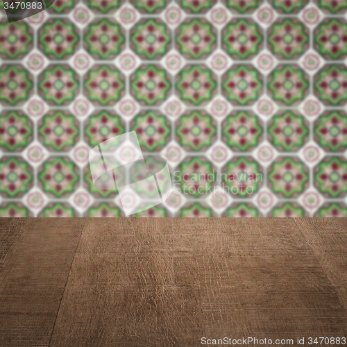 Image of Wood table top and blur vintage ceramic tile pattern wall