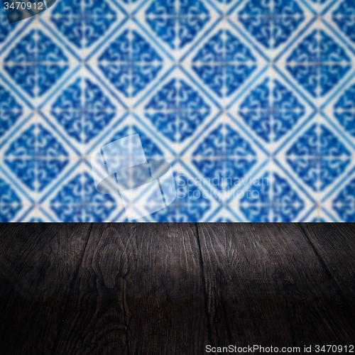 Image of Wood table top and blur vintage ceramic tile pattern wall