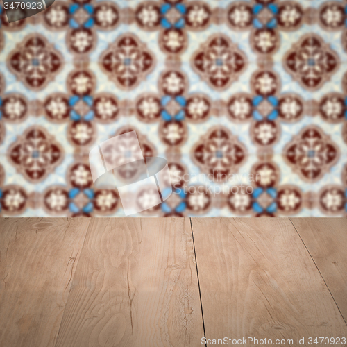 Image of Wood table top and blur vintage ceramic tile pattern wall