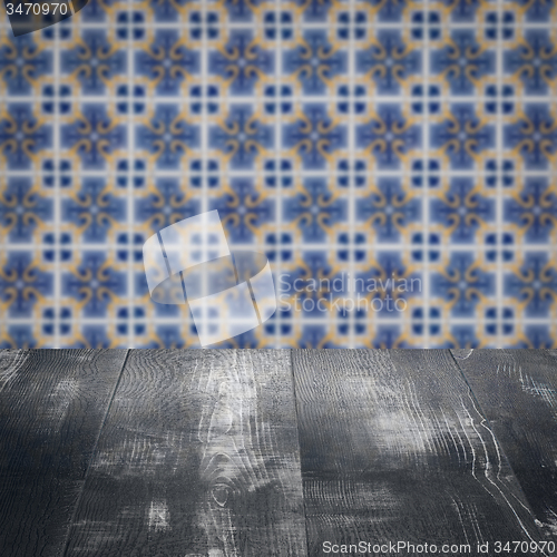 Image of Wood table top and blur vintage ceramic tile pattern wall