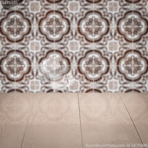Image of Wood table top and blur vintage ceramic tile pattern wall