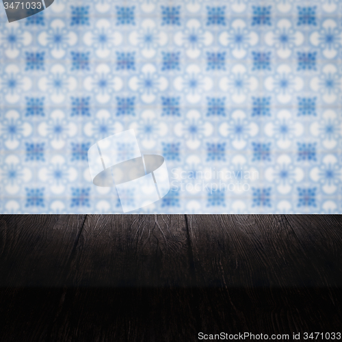 Image of Wood table top and blur vintage ceramic tile pattern wall