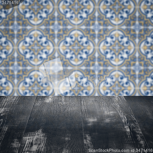 Image of Wood table top and blur vintage ceramic tile pattern wall