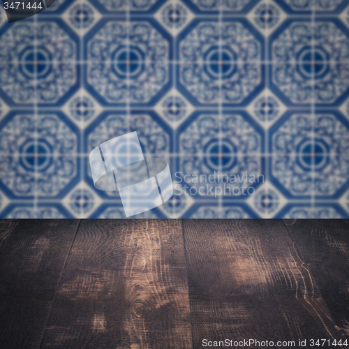 Image of Wood table top and blur vintage ceramic tile pattern wall