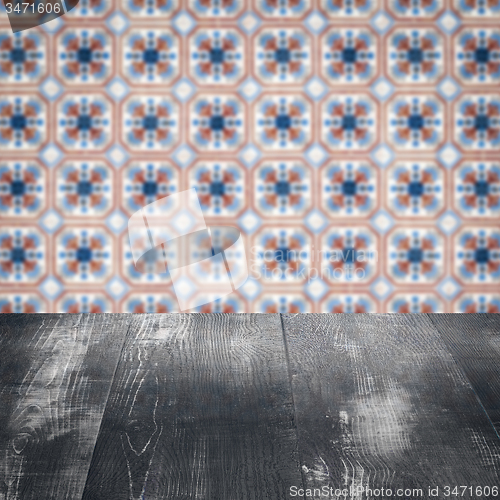 Image of Wood table top and blur vintage ceramic tile pattern wall