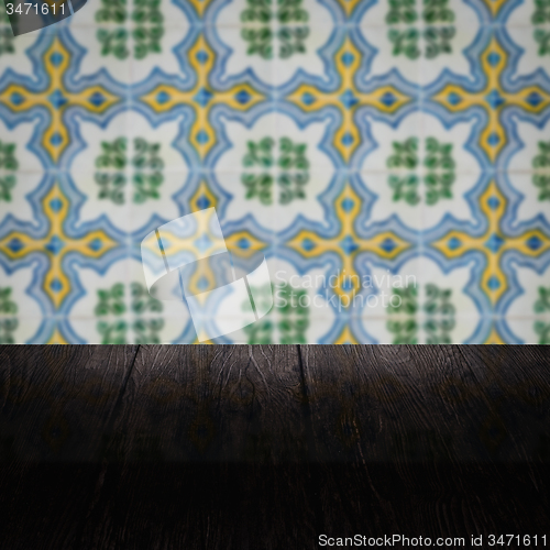 Image of Wood table top and blur vintage ceramic tile pattern wall
