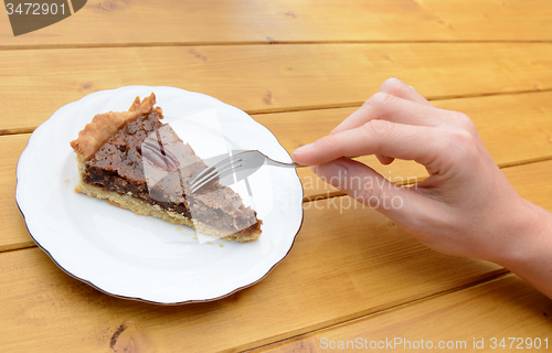 Image of Woman cutting into a slice of pecan pie