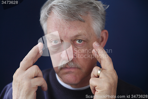 Image of senior man crossing his fingers 