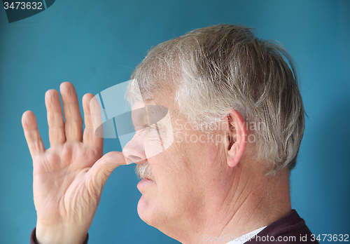 Image of Older man thumbs his nose.