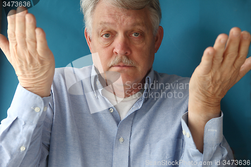 Image of older man with his hands up