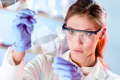 Image of Young scientist pipetting in life science laboratory.