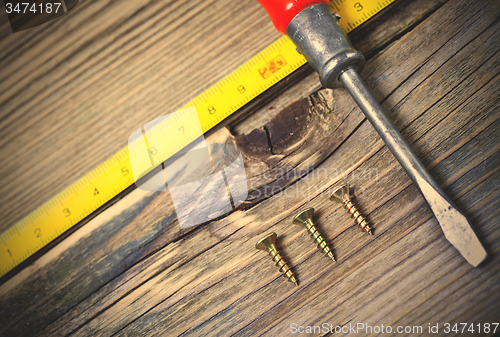 Image of antique screwdriver, screws and measuring lenght 