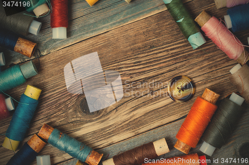 Image of one vintage button and coils of different threads