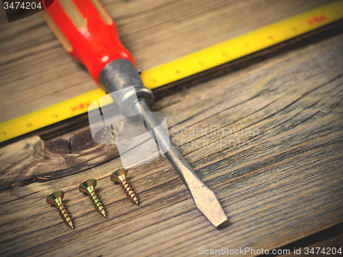 Image of screwdriver, screws and measuring lenght