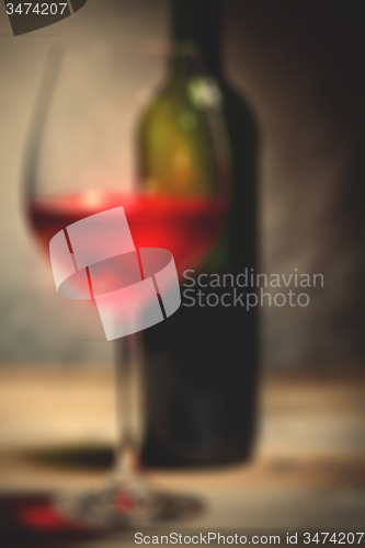 Image of red wine in a glass and green bottle