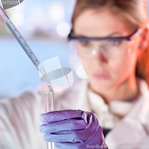 Image of Young scientist pipetting in life science laboratory.