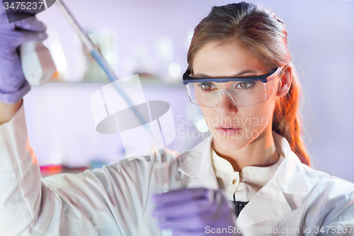 Image of Young scientist pipetting in life science laboratory.