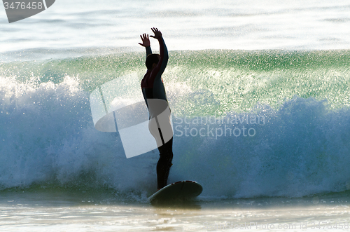 Image of Long boarder surfing the waves at sunset