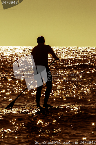 Image of Silhouette paddle board surfer