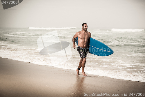 Image of Surfer running on the beach