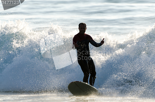 Image of Long boarder surfing the waves at sunset