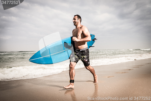 Image of Surfer running on the beach