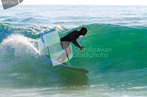 Image of Long boarder surfing the waves at sunset