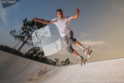 Image of Skateboarder in a concrete pool 