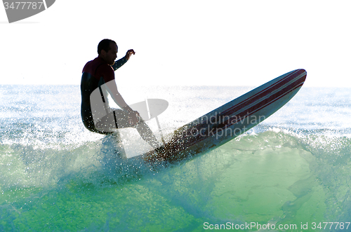 Image of Long boarder surfing the waves at sunset