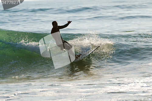 Image of Long boarder surfing the waves at sunset