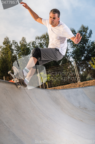 Image of Skateboarder in a concrete pool 