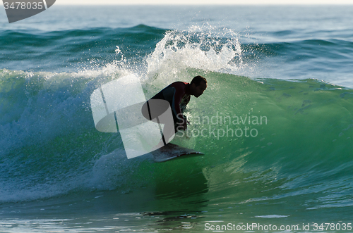 Image of Long boarder surfing the waves at sunset