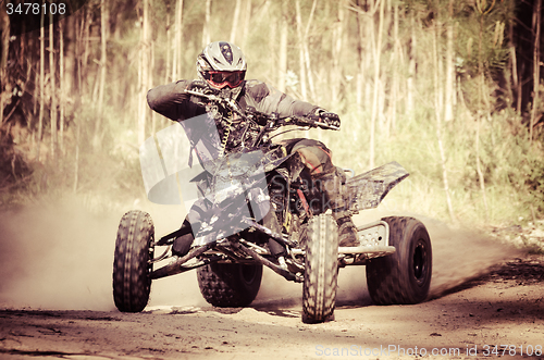 Image of ATV racer takes a turn during a race. 