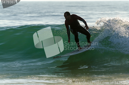 Image of Long boarder surfing the waves at sunset